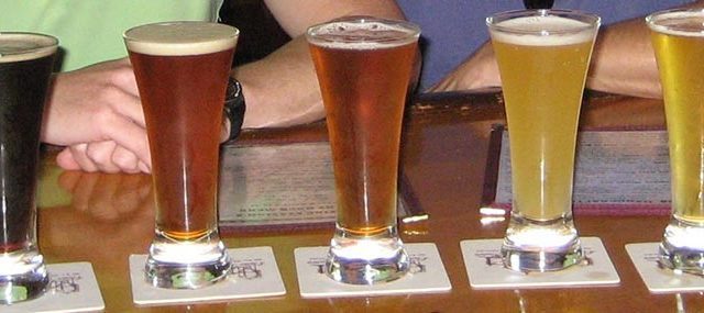 A rainbow of different colored beers ascending.